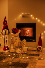 Portrait of cute boy wearing santa hat while sitting by fireplace at home