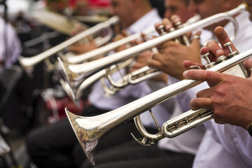 Wind instruments. Hands on musical instruments. Musicians play pipes.  Hands of man playing the trumpet in the orchestra