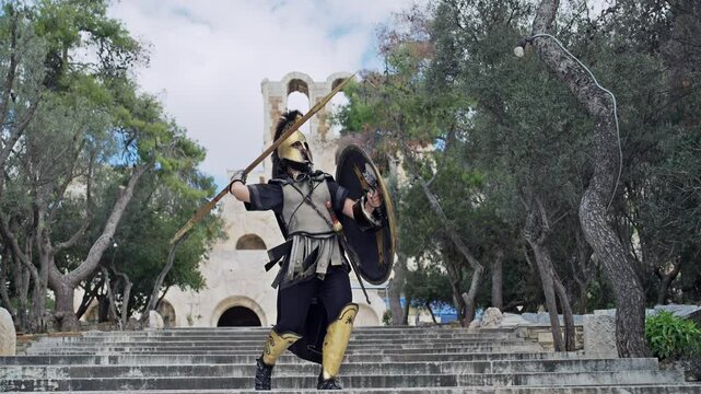 Spartan soldier in ancient uniform with helmet and shield attacking throwing spear at Acropol in Athens, cinematic slow motin isolated shot