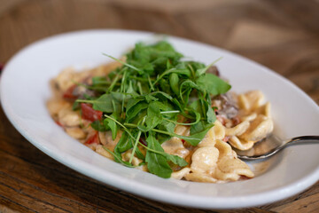 Pasta with meat and arugula.