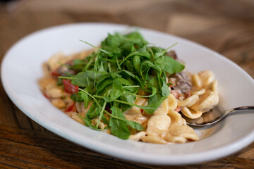 Pasta with meat and arugula.