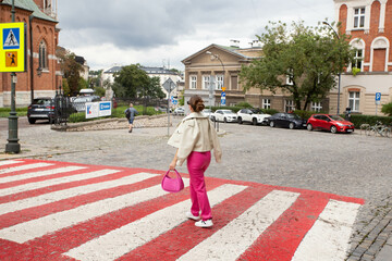 woman crossing street on sunny day