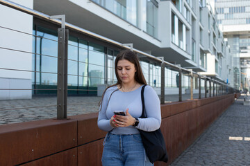 a girl is standing and looking at the phone