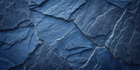 Dark blue slate rock texture background with rough and cracked stone layers, creating a natural,...