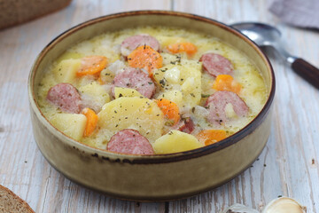 A bowl with traditional German potato soup with sausages