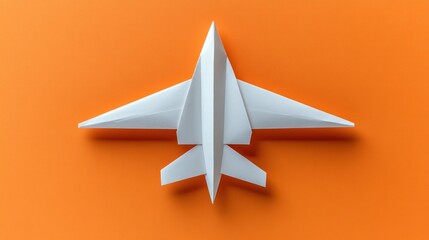 A white origami airplane model on an orange background.