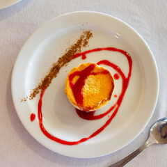 Tender creamy mousse cheesecake with currant sauce on white plate