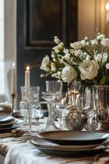 Elegant table setting with white flowers, candles, glassware.
