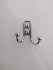 Coat or bag hook with two horns on white wall or door