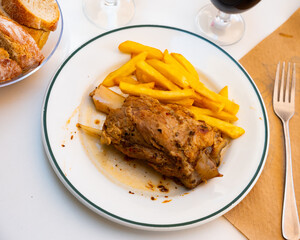 Fried knuckle (codillo rustido) with potatoes on plate