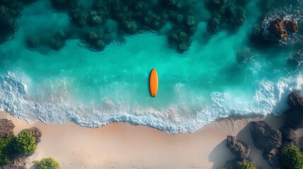 Aerial view of orange surfboard on turquoise beach.
