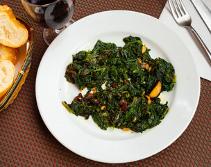 Delicious salad with spinach raisins and pine nuts served on plate