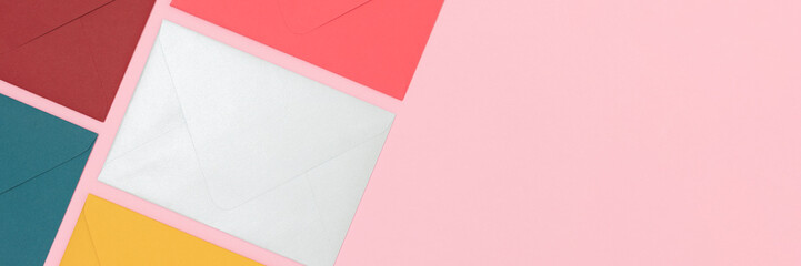 Banner with envelopes neatly laid out on a pink background.