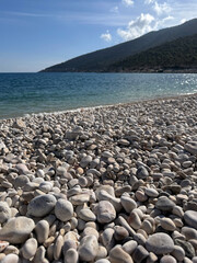 Beautiful pebbled beach and calm turquoise waters under a bright blue sky