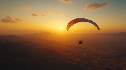 Paraglider gliding gracefully over a scenic landscape at sunset