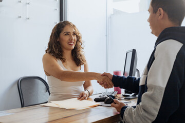 Mexican woman shaking hands with man in office