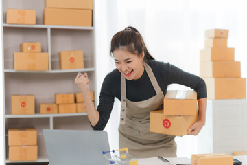 Online Business Success:  A young woman, filled with excitement and joy, celebrates a surge in online sales, surrounded by  packages, ready to ship.