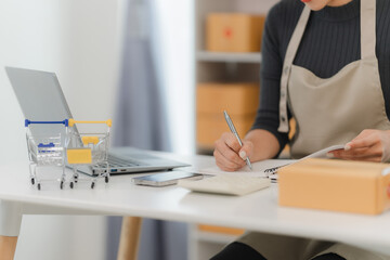 Small Business Owner Taking Orders: A close-up shot of a woman's hands meticulously taking orders...