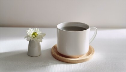 Coffee in a neatly designed mug with a small flower next to it