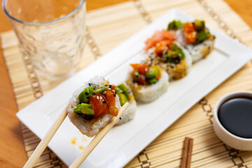Saketaki roll in service plate with wasabi and soya-bean sauce and necessary table laying