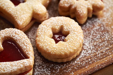 Closeup of traditonal Linzer Christmas cookies filled with strawberry marmalade and dusted with sugar