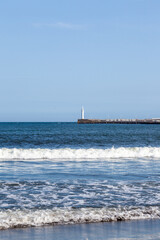 Calm Coastal Scene with Lighthouse and Gentle Ocean Waves