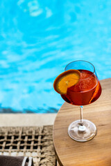 Refreshing tropical drink served in a glass with vibrant garnishes, placed poolside against a luxurious background. The image captures a relaxing vacation vibe, perfect for promoting travel, leisure, 