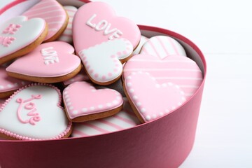 Delicious heart shaped cookies in box on white table, closeup. Valentine's Day