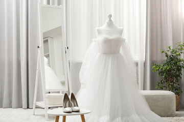 Beautiful wedding dress on mannequin and shoes in boutique