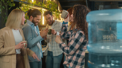 Happy multiracial group friends team mates freelance co-workers students colleagues joyful business men women diverse girls guys dancing male female buddies drink coffee dance laugh office break party