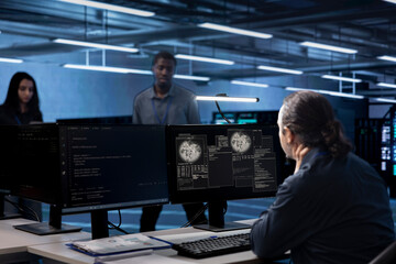 Admin working in data center accommodating traffic for people from worldwide locations. Employee at computer desk in server hub hosting websites and delivering web content to clients over the internet