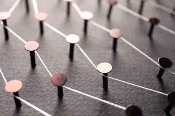 Network connection. Nails linked together by thread on color background, closeup