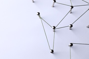 Network connection. Nails linked together by threads on white background, above view. Space for text