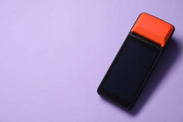 One payment terminal on violet background, top view. Space for text