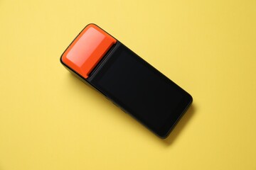 One payment terminal on yellow background, top view