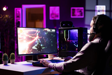 Streamer in studio streaming for online viewers, talking with them, creating content. Pro gamer broadcasting from dark living room, greeting fans watching him on online channel