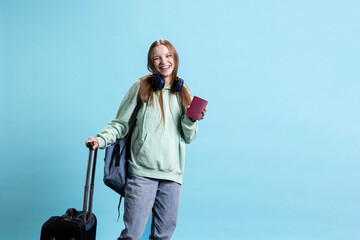 Upbeat teenager holding passport document, going to airport departure gates to reach destination....