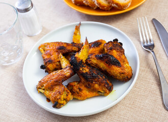 Cooked and served on plate appetizing chicken wings for dinner