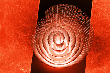 Abstract spiral with glowing red and orange tones and wire texture against a black background,...