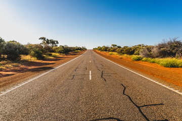 Australien road in the Outback with trees on the Roadside