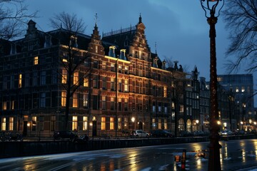 Naklejka premium Traditional dutch houses are illuminated along an amsterdam canal at twilight