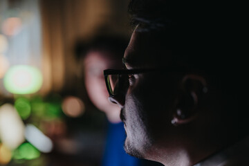 Two business people collaborate late at night, intensely focused on their project. The dimly lit...