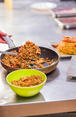 Chef preparing Chaulafan con marisco traditional ecuadorian dish in ecuadorian restaurant