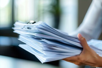 Office worker is holding a large stack of paperwork documents