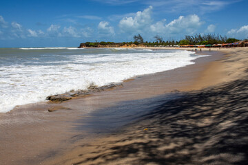 Scenic view of Tourinhos Beach in Sao Miguel do Gostoso, Rio Grande do Norte, Brazil, on a sunny day. The pristine sand, blue sky, and turquoise sea create a perfect coastal landscape