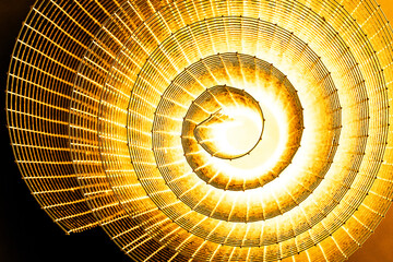 Abstract spiral with glowing yellow wire texture against a black background, symbolizing color...
