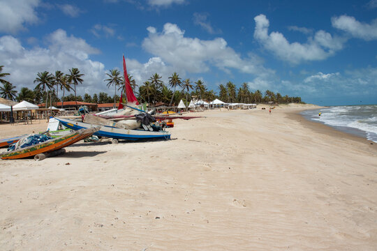 A traditional jangada boat anchored at Perobas Beach in Touros, Rio Grande do Norte, Brazil. This photo captures the coastal life and fishing culture of Northeast Brazil with serene beach views