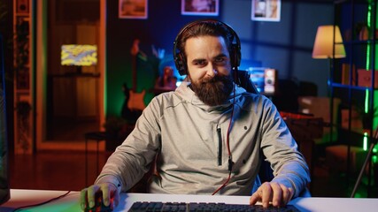 Mad gamer raging after losing online competitive multiplayer match, playing on cutting edge gaming setup. Man feeling angry and shouting after being defeated in videogames