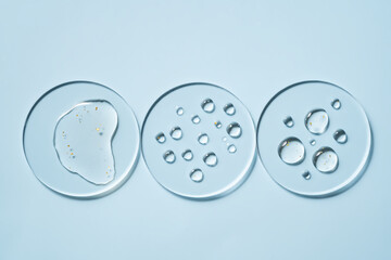 Transparent petri dish with water gold drops on light blue background