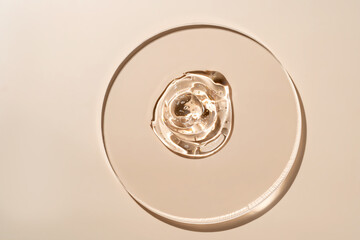 Close-up of a serum golden droplet on a glass surface in warm light